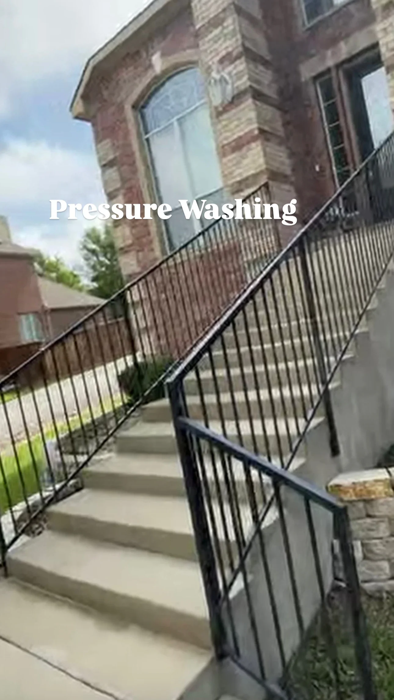 Pressure-washed brick building facade and concrete stairs with metal railings