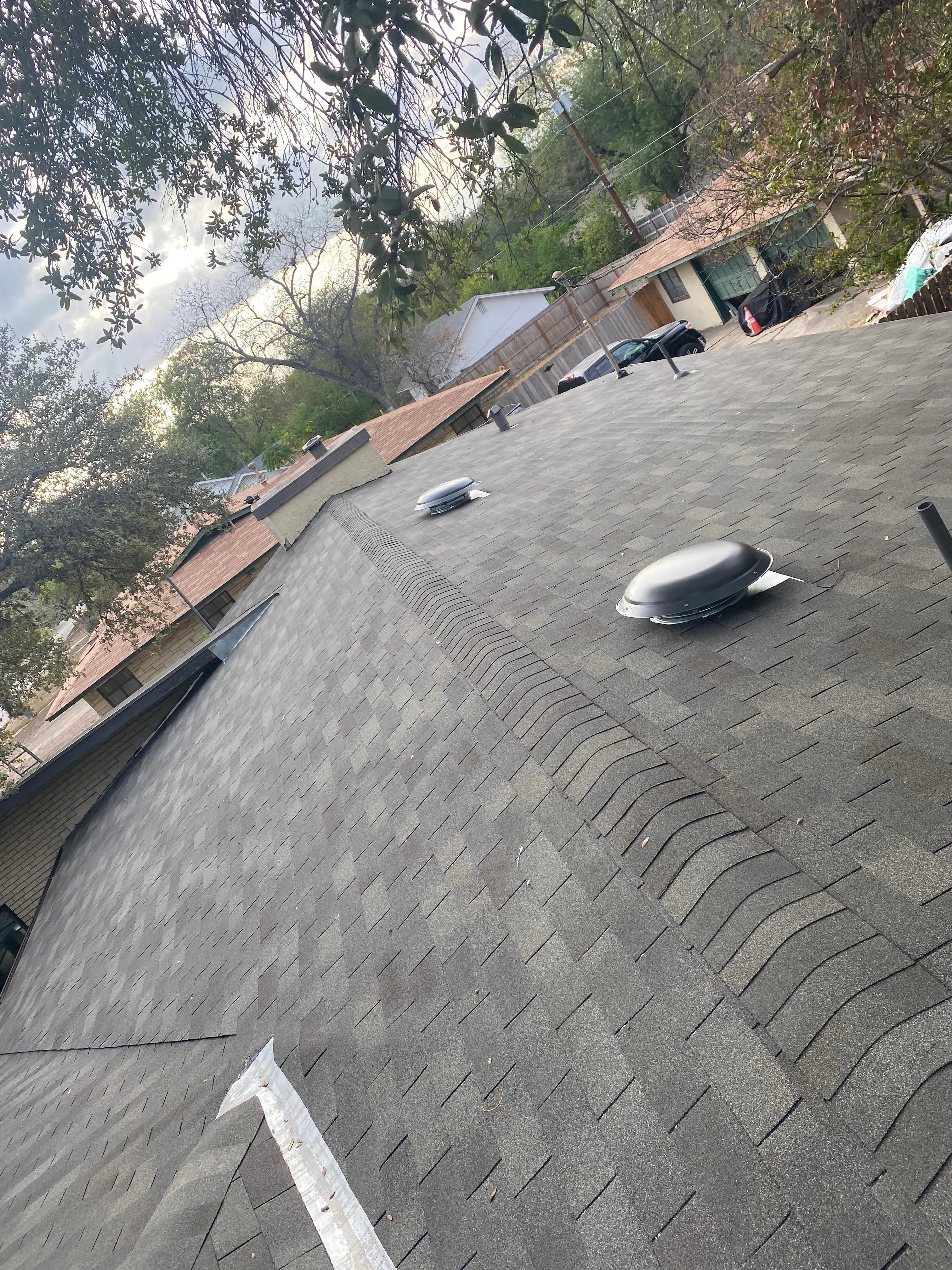 Newly installed asphalt shingle roof with architectural shingles and roof vents on residential home