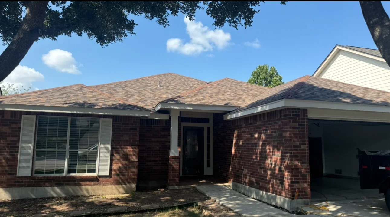 New architectural shingle roof installation on brick residential home with brown tones