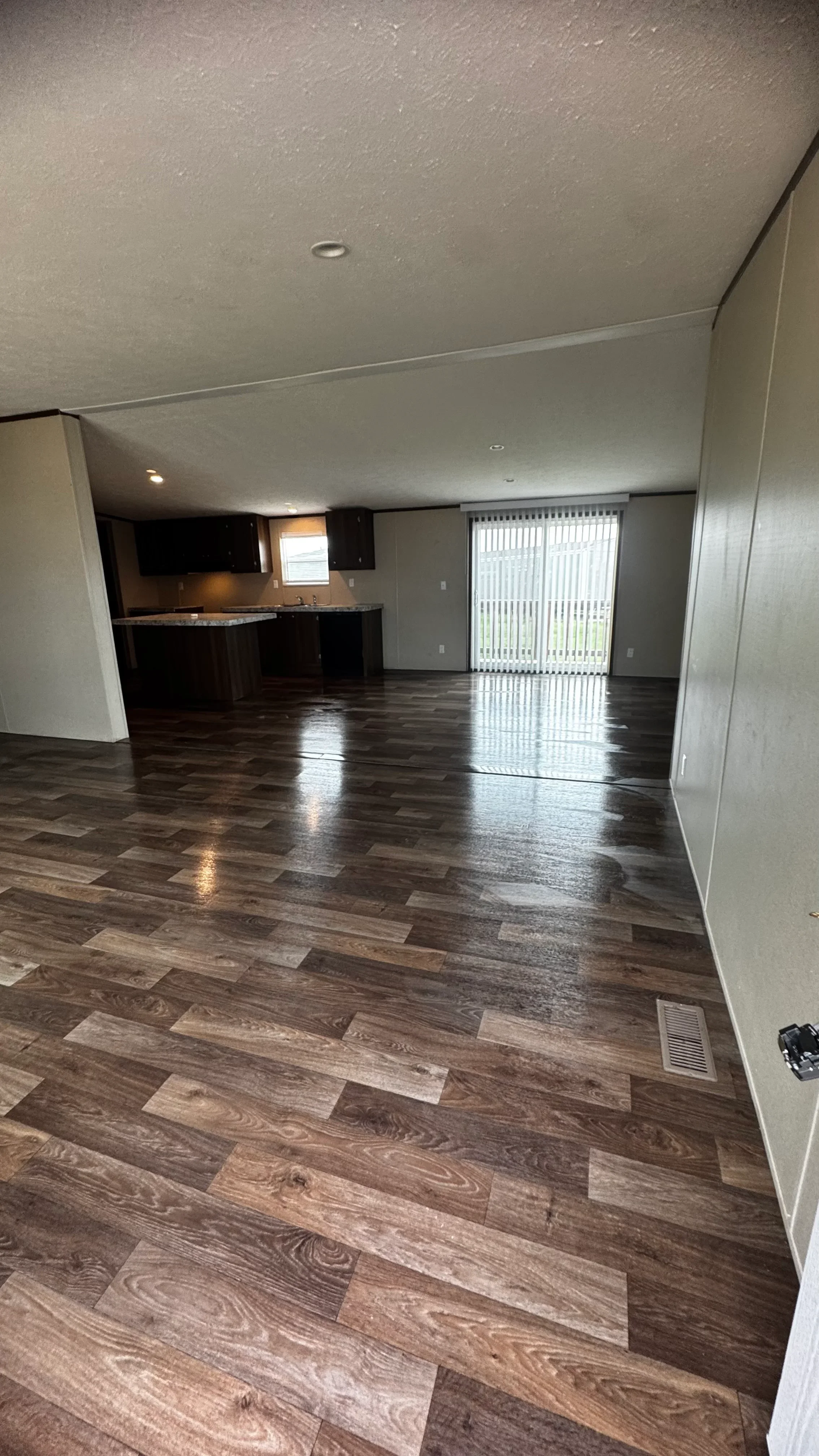 Luxury vinyl plank flooring installation in open living area with dark wood-grain pattern