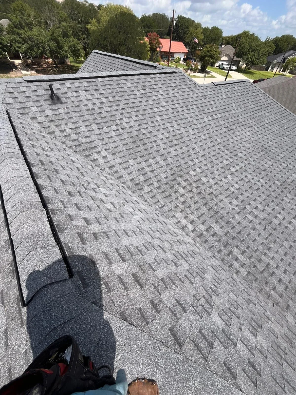 Gray architectural shingles installed on residential roof with clean valleys and edge details