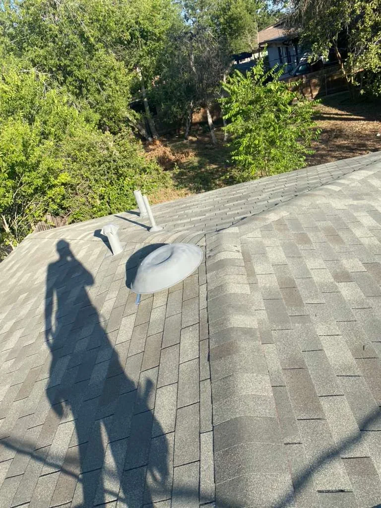 New gray architectural shingles installed on pitched residential roof with proper alignment and overlap