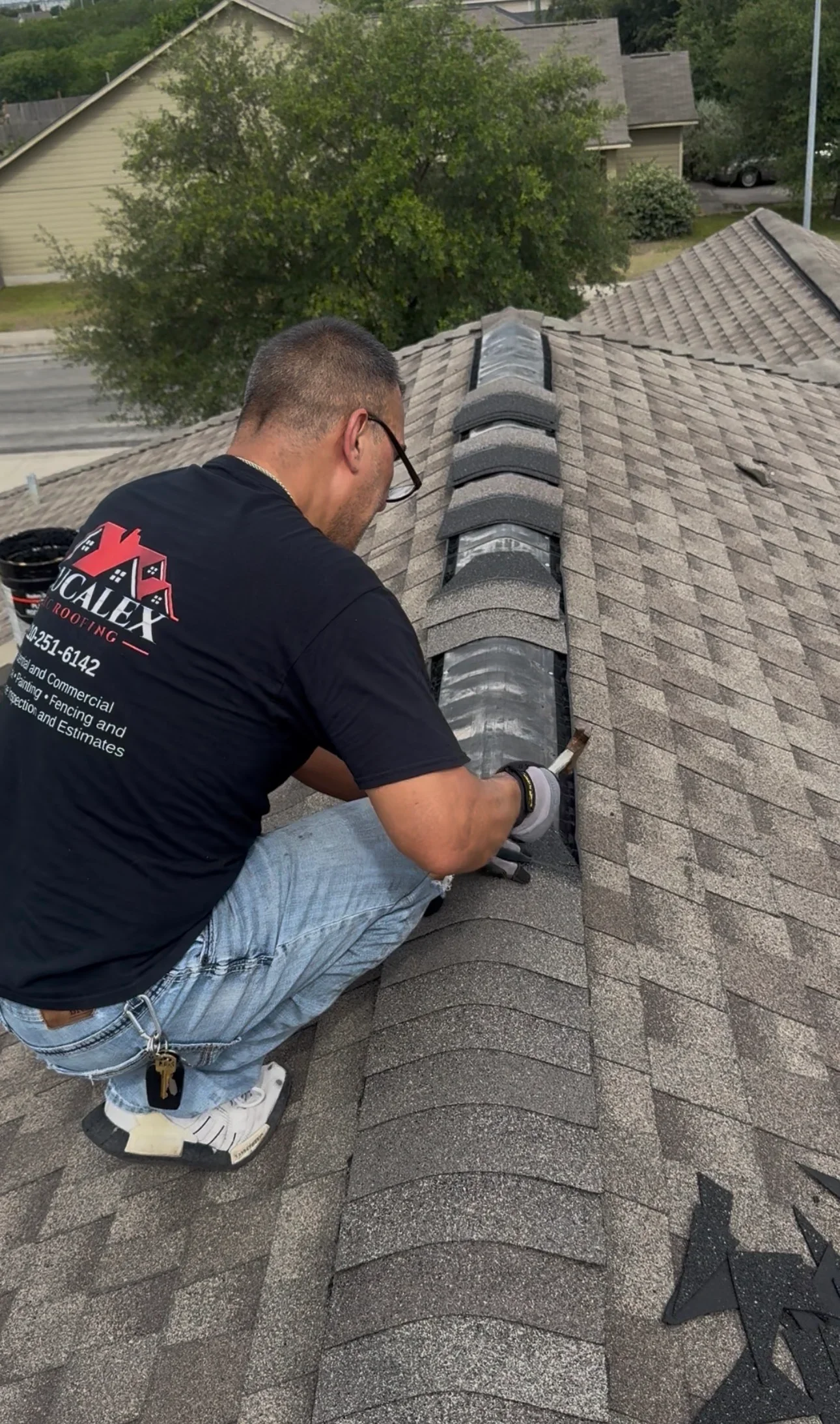 Roofer installing roof vent with flashing on asphalt shingle roof