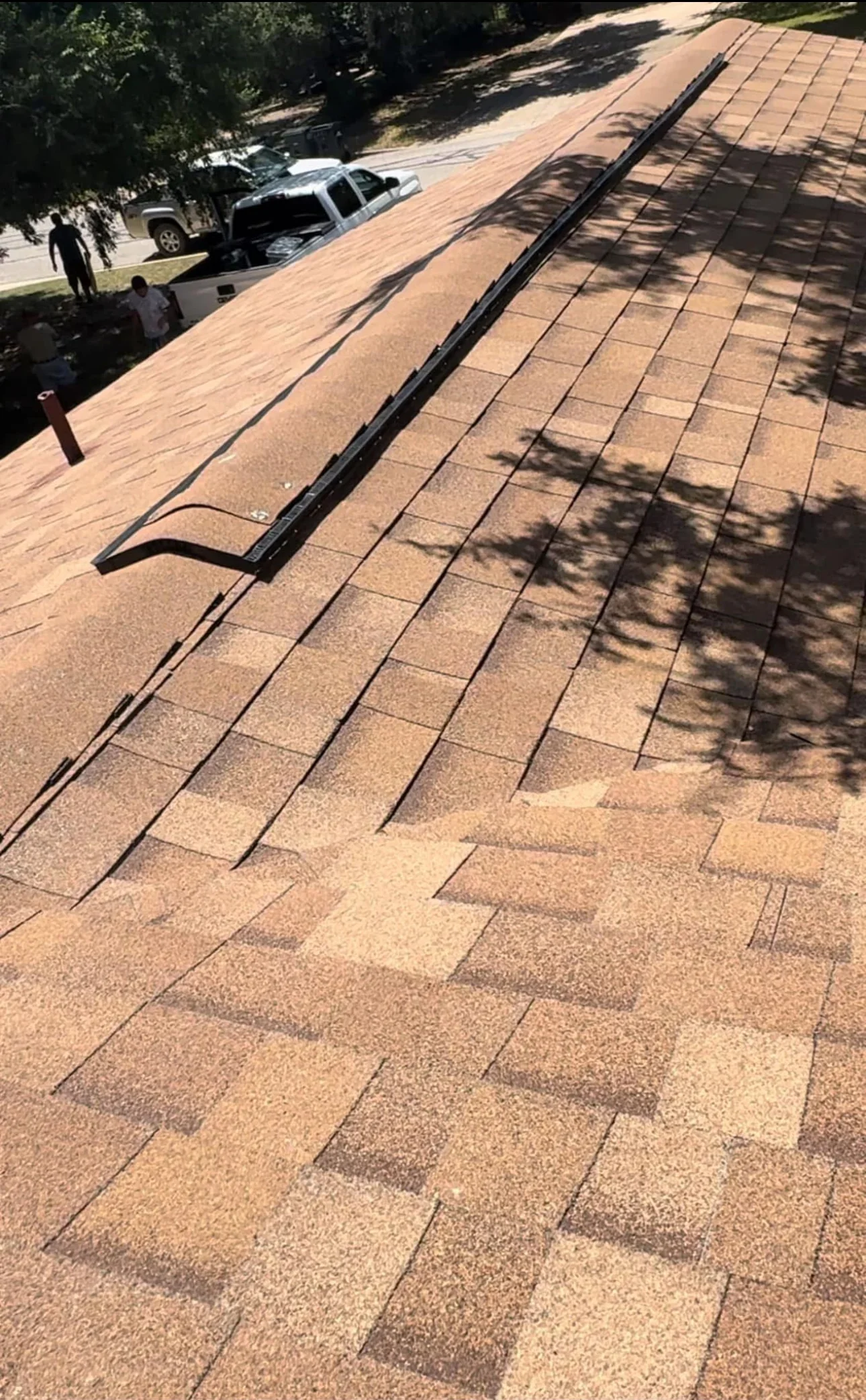 Newly installed asphalt shingles with black metal flashing on residential roof