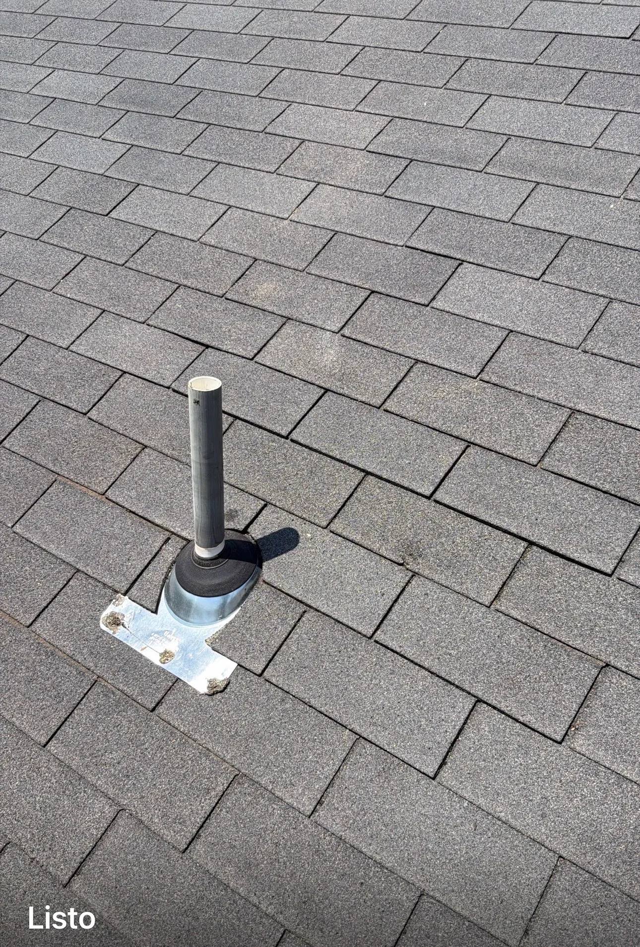 Installed roof vent pipe with metal collar and rubber boot on gray asphalt shingles